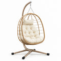 Sedia a dondolo sospesa in rattan con cuscino crema e struttura in metallo